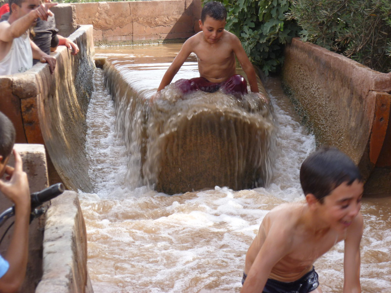 Children are playing in the water canal