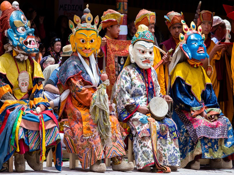 Monks perform at the Hemis festival by dancing and wearing multicoloured masks.